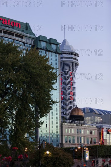 Tall hotel and casino buildings with bright signage against an evening sky in Niagara Falls, Ontario, Canada, North America