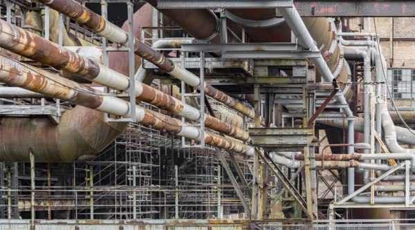 Weathered rundown industrial scenery with old corroded steel girders and metal tubes