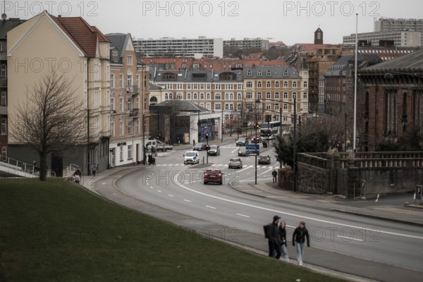 City street view with cars and pedestrians, lined with historic buildings under a gray sky in Aarhus, Denmark, Northern Europe