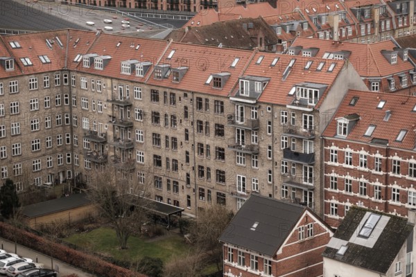 View of apartment buildings with red tile rooftops under a cloudy sky in Aarhus, Denmark, Northern Europe