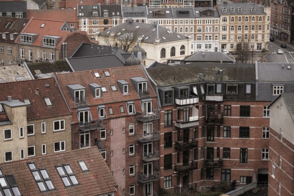 Cityscape featuring residential buildings with red tile roofs under an overcast sky in Aarhus, Denmark, Northern Europe