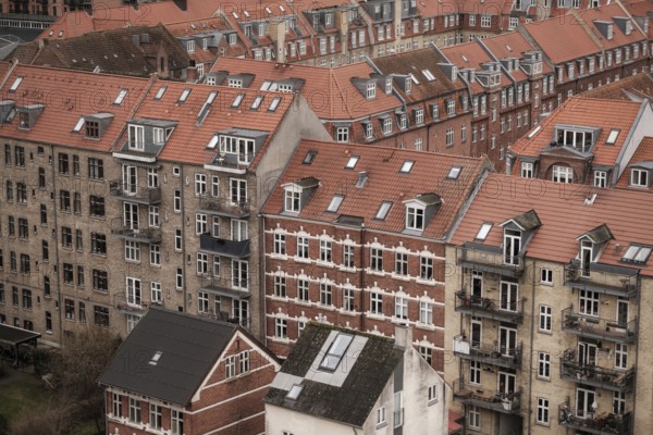 Urban scene showcasing densely packed buildings with red tile roofs on a cloudy day in Aarhus, Denmark, Northern Europe