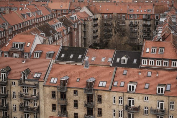 Rooftop view of densely packed residential buildings with red tile roofs under an overcast sky in Aarhus, Denmark, Northern Europe