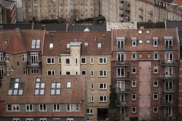 Close-up of red-tiled residential buildings with various windows and balconies in an urban setting in Aarhus, Denmark, Northern Europe