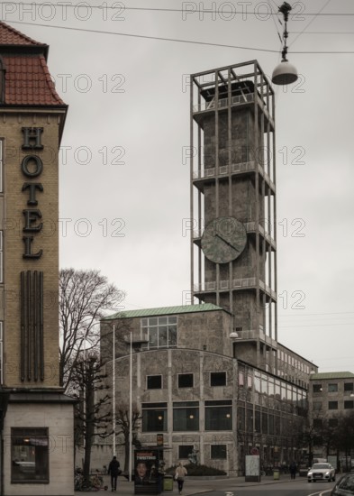 A modern concrete building with a large clock under a gray sky in Aarhus, Denmark, Northern Europe