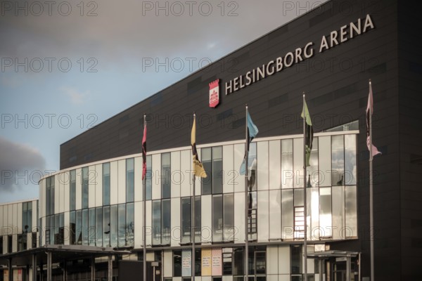 Modern architecture of Helsingborg Arena with flags and large windows under an overcast sky in Helsingborg, Sweden, Scandinavia, Northern Europe
