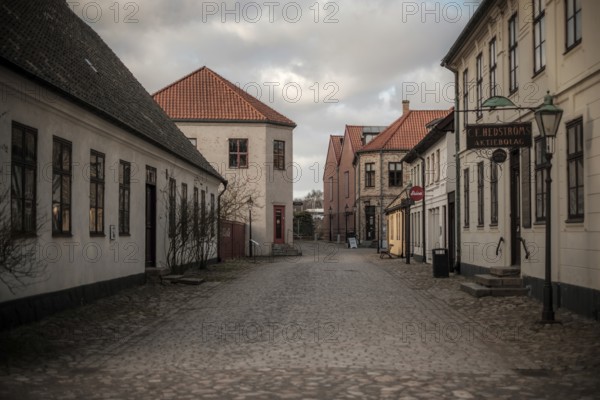 An empty street lined with buildings under a cloudy sky, vintage signs adding to the quiet atmosphere in Helsingborg, Sweden, Scandinavia, Northern Europe