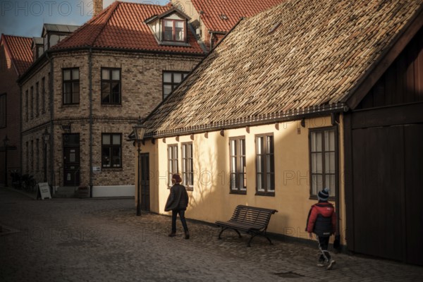 A quiet street with brick buildings and tile roofs, bathed in warm autumn light and shadows in Helsingborg, Sweden, Scandinavia, Northern Europe