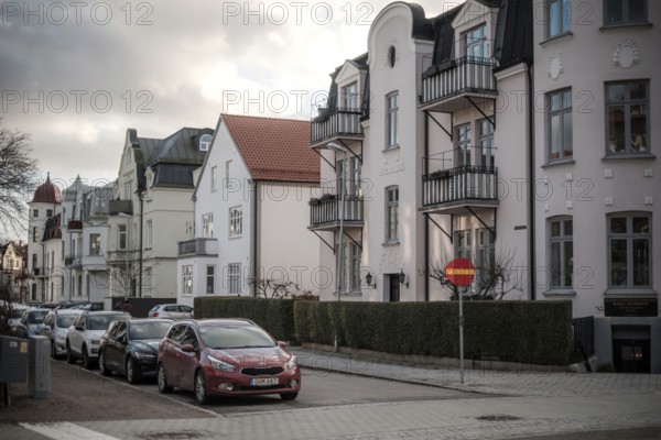 Street view of European residential buildings with parked cars and a cloudy sky in Helsingborg, Sweden, Scandinavia, Northern Europe