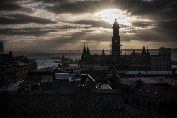 A silhouetted tower during sunset with a dramatic cloudscape and looking out to the Oresund Strait, between Sweden and Denmark, as seen from Helsingborg, Sweden, Scandinavia, Northern Europe