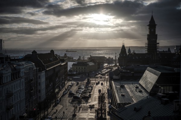 A dramatic city view with a silhouette against a sunset over the Oresund Strait, between Sweden and Denmark, as seen from Helsingborg, Sweden, Scandinavia, Northern Europe