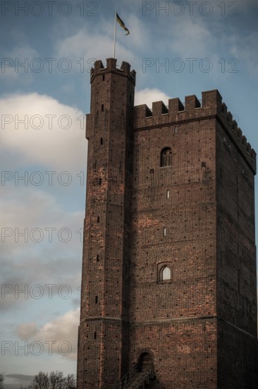 The Karnan medieval tower, built in the early 14th century, with a flag set against a blue sky with clouds in Helsingborg, Sweden, Scandinavia, Northern Europe