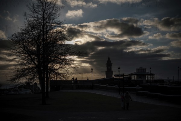 Silhouette of figures and a tower at sunset with a dramatic cloud-filled sky in Helsingborg, Sweden, Scandinavia, Northern Europe
