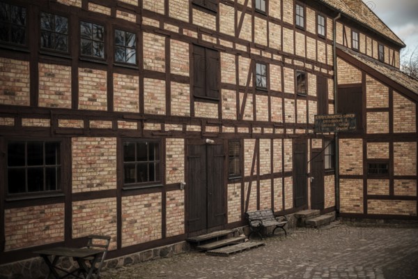 Historic brick building with wooden beams and benches, featuring cobblestone pavement in Helsingborg, Sweden, Scandinavia, Northern Europe