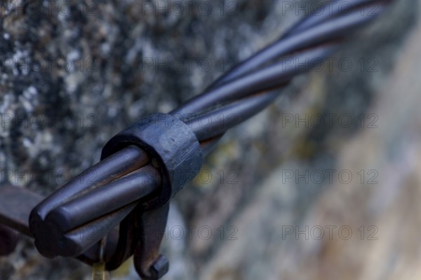 Steel cable railing showing a strong metal connection detail on a stone wall in ronda, malaga, spain
