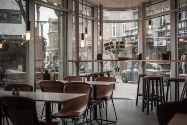 A modern cafe interior with wooden chairs and a large window view to the street in Helsingborg, Sweden, Scandinavia