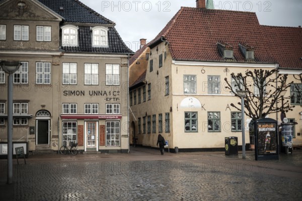 Daytime scene with historic buildings lining an empty cobblestone square in Helsingor, Denmark, Northern Europe