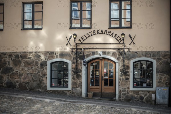 Charming building with a stone wall and decorative entrance on cobblestone street in Helsingborg, Sweden, Scandinavia