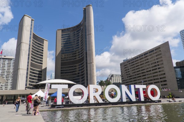 Toronto sign in front of Toronto City Hall with a bright blue sky in Toronto, Ontario, Canada, North America