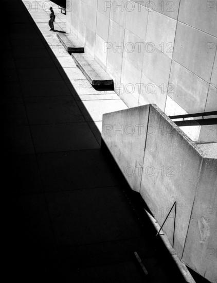 Geometric black and white scene with sharp shadows and a solitary person against a wall in Toronto, Ontario, Canada, North America