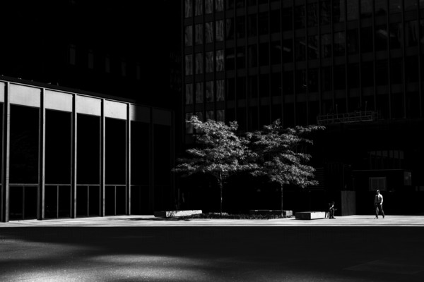 A lone person in a stark urban setting with dramatic light and shadow interplay, emphasizing isolation in Toronto, Ontario, Canada, North America