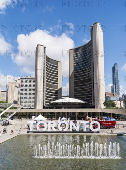 Toronto sign by a fountain against a backdrop of Toronto City Hall at Nathan Phillips Square in Toronto, Ontario, Canada, North America