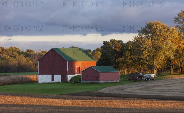 Red barn and fields illuminated by warm sunset in St. Thomas, Ontario, Canada, North America
