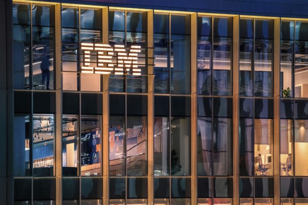 Jan 15, 2025 - Lisbon, Portugal: Nighttime view of IBM office building with glowing logo and sleek glass exterior. Illuminated interior spaces and reflections, innovative spirit and global presence of renowned technology corporation, corporate life