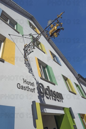 Blue sky, Hotel-Gasthof-Ochsen with nose sign and colourful windows in Kisslegg, Allgäu, Baden-Württemberg, Germany