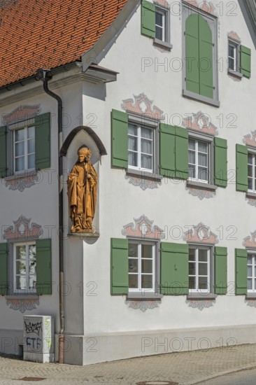Blue sky, pointed gable house with green shutters and bishop figure, Kisslegg, Allgäu, Baden-Württemberg, Germany