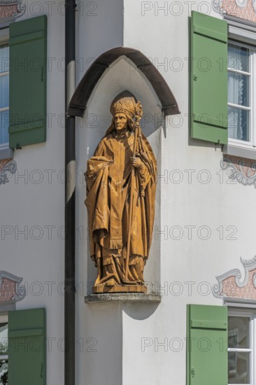 Blue sky, house with green shutters and bishop figure in corner niche, Kisslegg, Allgäu, Baden-Württemberg, Germany