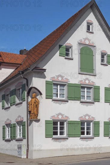 Blue sky, pointed gable house with green shutters and bishop figure, Kisslegg, Allgäu, Baden-Württemberg, Germany