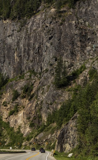 Winding road through a rugged mountainous area with dense forest in Revelstoke, British Columbia, Canada, North America