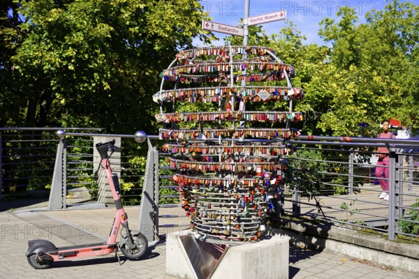 Electric scooter next to a large heart made of padlocks outdoors, Nuremberg, Middle Franconia, Franconia, Bavaria, Germany