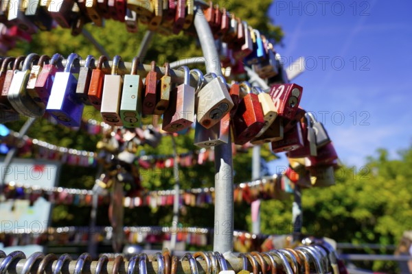 Several colourful padlocks attached to a metal frame outdoors, Nuremberg, Middle Franconia, Franconia, Bavaria, Germany