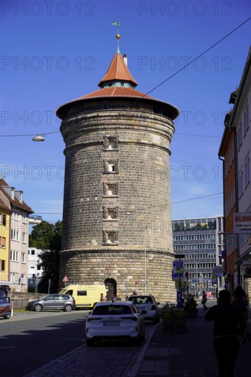 Massive round tower made of bricks, surrounded by city buildings under a clear sky, Nuremberg, Middle Franconia, Franconia, Bavaria, Germany