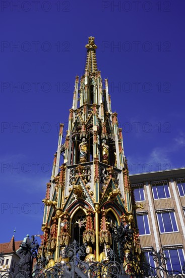 Gothic fountain, richly decorated, rises proudly under a bright blue sky, Nuremberg, Middle Franconia, Franconia, Bavaria, Germany