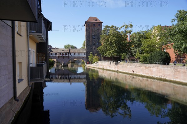 Picturesque river view with old buildings and bridge, peaceful atmosphere under blue sky, Nuremberg, Middle Franconia, Franconia, Bavaria, Germany