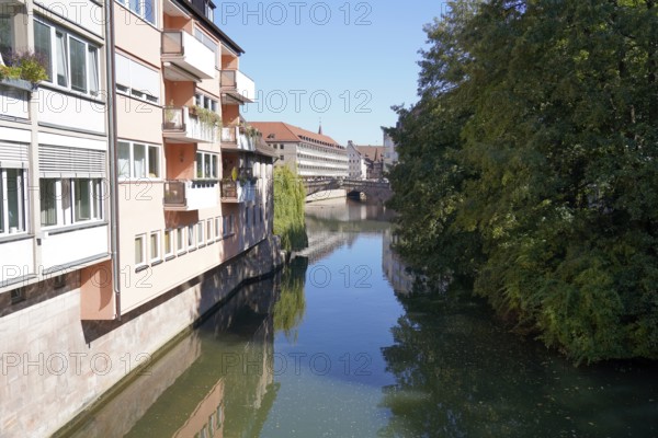 Quiet river between buildings and trees with a bridge in the background, Nuremberg, Middle Franconia, Franconia, Bavaria, Germany