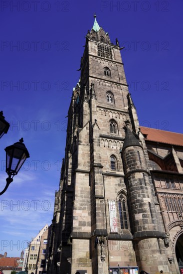 Gothic church tower made of sandstone, rises in front of a bright blue sky, Church of St. Lawrence, Nuremberg, Middle Franconia, Franconia, Bavaria, Germany