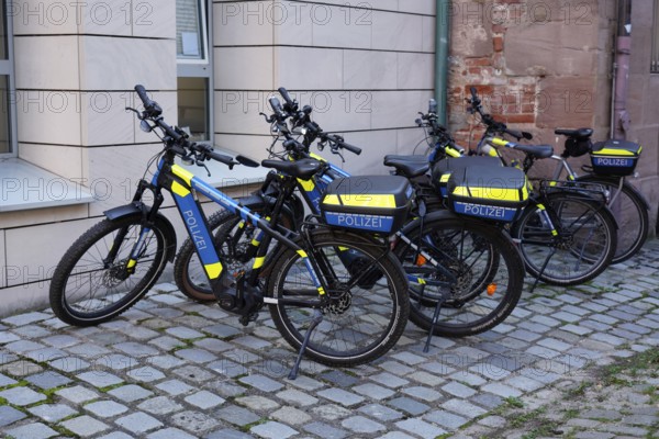 Police bikes with neon-coloured elements parked on cobblestones, Nuremberg, Middle Franconia, Franconia, Bavaria, Germany
