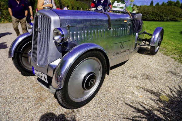 DKW, built in 1937, Oldtimer Classic, Gala International Concours d'Elegance Schwetzingen 2025, Germany, Europe, Silver classic car with chrome details stands on a gravel path in the sun, surrounded by greenery