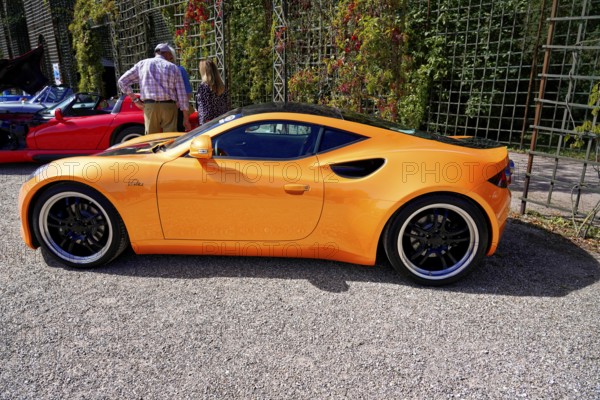 Artega, year of construction 2011, Oldtimer Classic, Gala International Concours d'Elegance Schwetzingen 2025, Germany, Europe, side view of an orange Artega sports car, surrounded by people in the sunshine