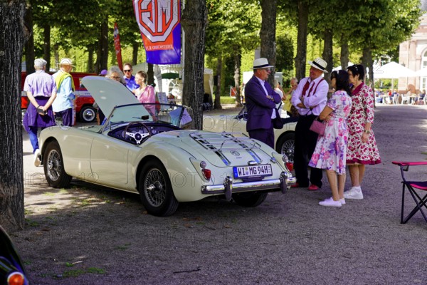 Oldtimer Classic, Gala International Concours d'Elegance Schwetzingen 2025, Germany, Europe, people in conversation next to a vintage MG in a park