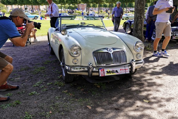 Oldtimer Classic, Gala International Concours d'Elegance Schwetzingen 2025, Germany, Europe, A white vintage MG is photographed in a park by a photographer