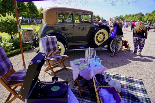 Oldtimer Classic, Gala International Concours d'Elegance Schwetzingen 2025, Germany, Europe, picnic scene with record player in front of a retro car, surrounded by people