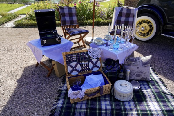 Oldtimer Classic, Gala International Concours d'Elegance Schwetzingen 2025, Germany, Europe, Nostalgic picnic arrangement with crockery and blanket next to a classic car