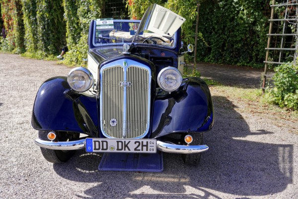 Oldtimer Classic, Gala International Concours d'Elegance Schwetzingen 2025, Germany, Europe, A blue classic car stands on a gravel path next to green trees in the sunlight