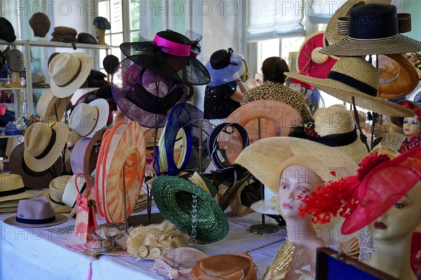 Oldtimer Classic, Gala International Concours d'Elegance Schwetzingen 2025, Germany, Europe, A table full of fashionable hats in different colours displayed in a shop