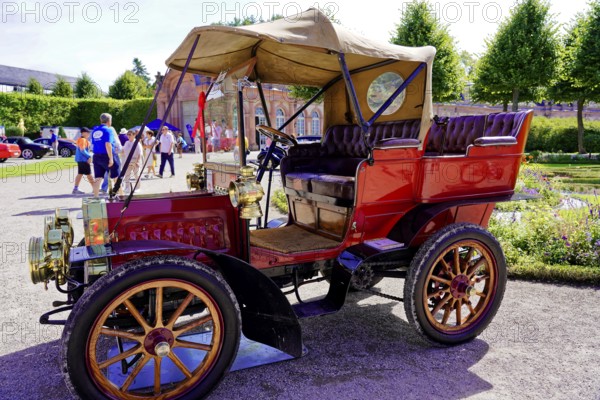 Oldtimer Classic, Gala International Concours d'Elegance Schwetzingen 2025, Germany, Europe, A red antique car with an open top stands in the sun in a historic park